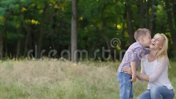4母亲和儿子在公园里儿子亲吻母亲视频的预览图