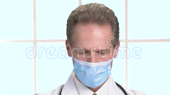 严肃的医生脸戴着蓝色面具工作视频的预览图