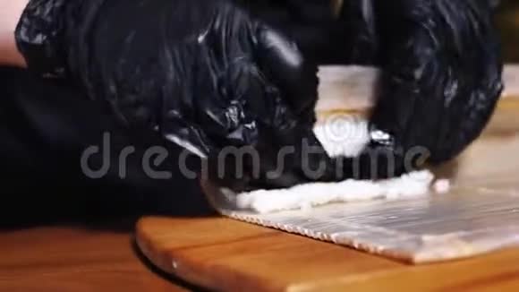 寿司大师的特写他的手戴着黑色手套做美味的寿司用竹垫卷框架传统视频的预览图