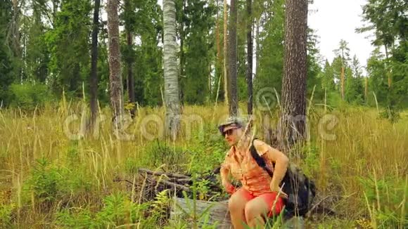 女游客带着背包在树林里休息视频的预览图