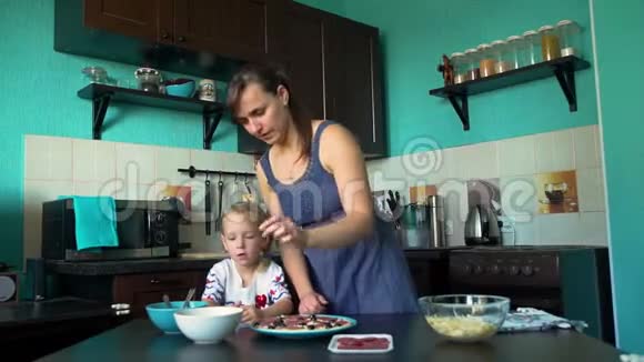 母亲和女儿把橄榄放在披萨基地视频的预览图