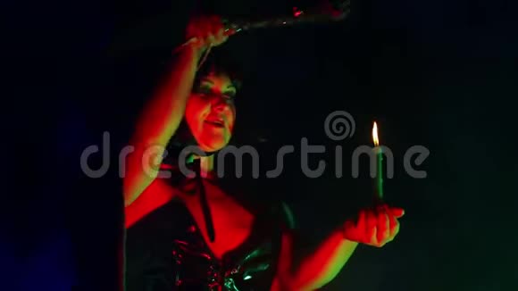 一个年轻女巫的脸在一个烟雾缭绕的讣告里手里拿着蜡烛念咒语用魔法对付魔法视频的预览图