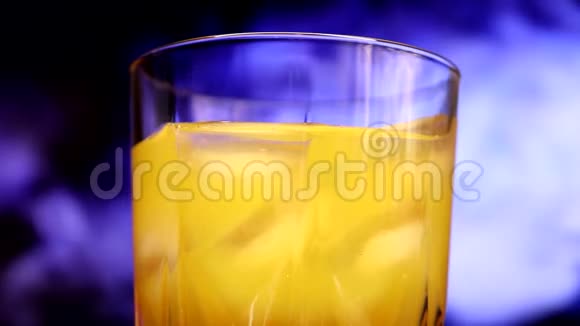 一杯黄色橙色甜多果汁和冰块视频的预览图