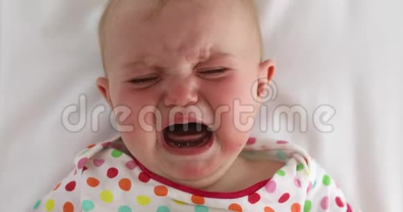 在白色背景下哭泣的婴儿的脸视频的预览图