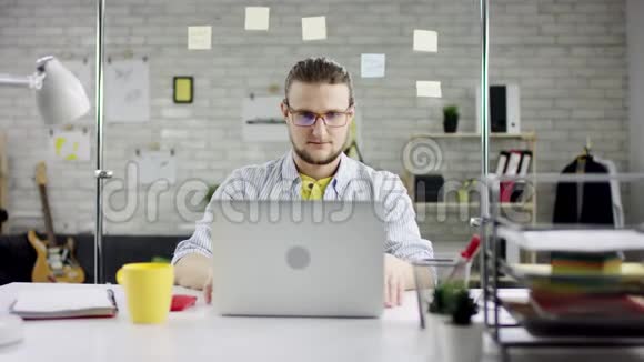 两名男性雇员站在女雇员的前面她白天坐在现代照明设计办公室的电脑前视频的预览图