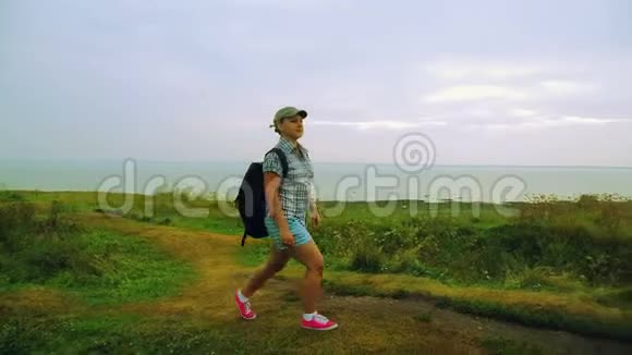 一个背着背包的女人走在山上的小路上视频的预览图