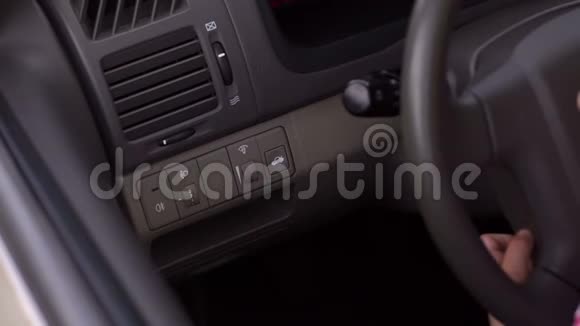 小男孩坐在汽车的车轮后面他按下按钮打开后备箱视频的预览图