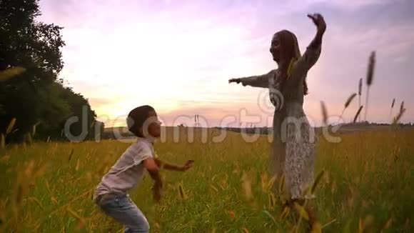 快乐的亚洲妈妈和她可爱的儿子在农村美丽的田野上跳跃视频的预览图