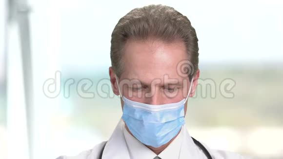 一个戴面具的医生闭上脸往下看视频的预览图