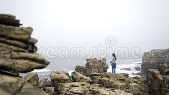 岩石海岸上认不出的雌性视频的预览图