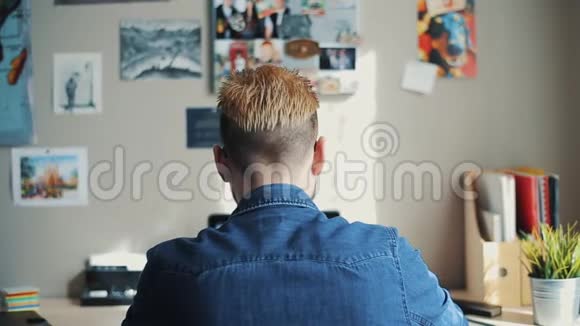 在家中可以看到英俊的男学生黄色的头发和时尚的发型看书使用教科书视频的预览图