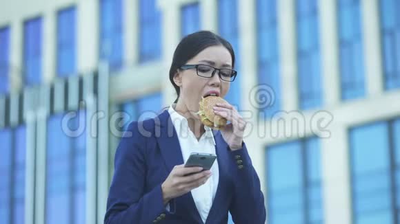 女办公室经理在电话里吃不健康的汉堡检查信息压力视频的预览图
