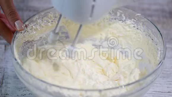 奶油和搅拌器将蛋奶油搅拌入搅拌机碗中视频的预览图