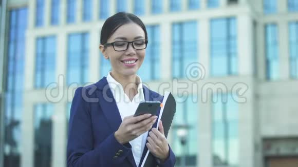 成功的微笑女士在智能手机上查看信息收到好消息视频的预览图