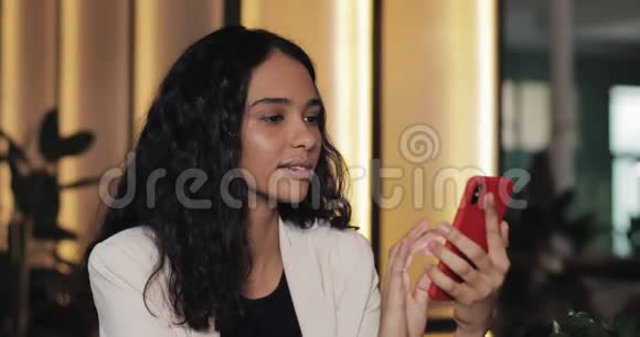 年轻快乐的女商人一边喝咖啡一边用手机发信息坐在咖啡厅的商务小姐视频的预览图