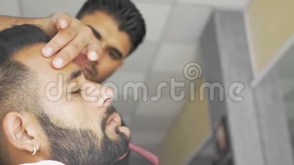 理发师在理发店里刮胡子视频的预览图