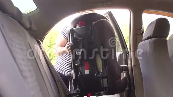 一名年轻女子在车内安装了一个安装有ISOFIX的儿童安全座椅视频的预览图
