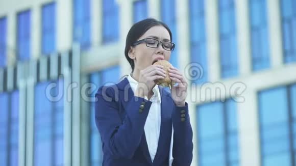 商务女士适合在午餐时间吃不健康汉堡工作压力大视频的预览图