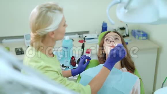 门诊定期复查牙医的女性患者有医生的病人视频的预览图