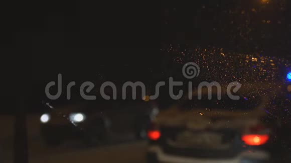 晚上掉在汽车挡风玻璃上带着闪烁的灯光路过救护车视频的预览图