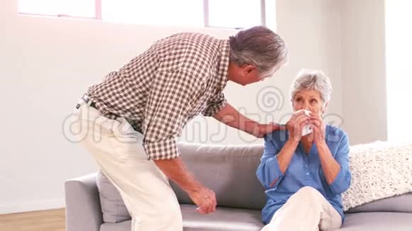 成熟的男人安慰妻子在沙发上哭泣视频的预览图