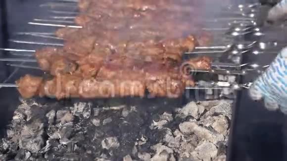 男人的手在烧烤时翻来覆去的是美味多汁的猪肉肉串视频的预览图