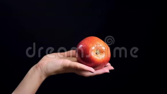 手里拿着多汁的红苹果覆盖着黑色的背景收获和健康饮食的理念女孩把苹果转过来视频的预览图