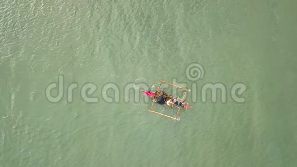鸟瞰渔民漂浮在渔船在海水中渔民们在渔船上划桨时的镜头视频的预览图