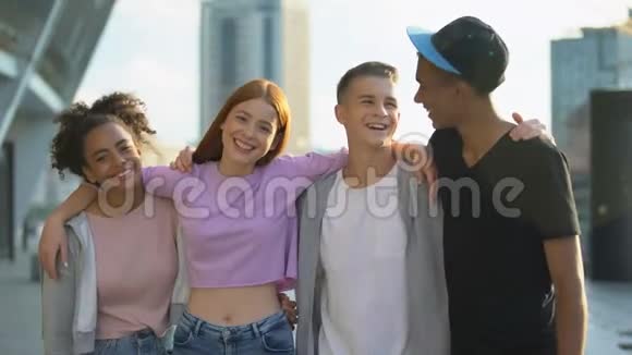 快乐的多种族朋友拥抱微笑的相机青少年的聚会视频的预览图