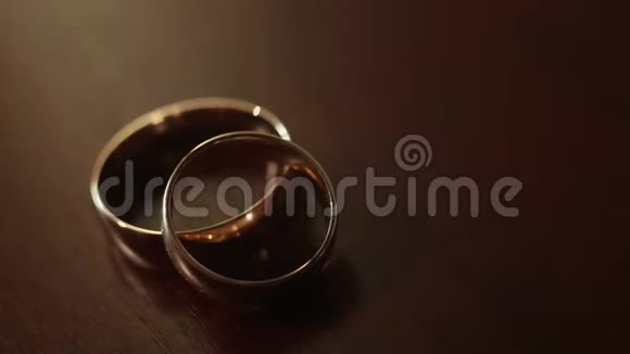 米色背景上的金色订婚戒指结婚戒指婚礼当天有两个华丽的结婚戒指两个结婚戒指视频的预览图