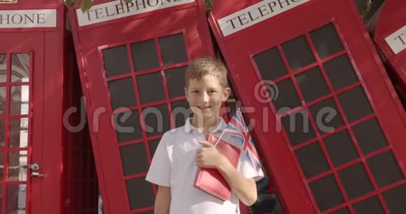 慢镜头肖像可爱的男孩站在户外独自微笑看相机背景为英文红色视频的预览图