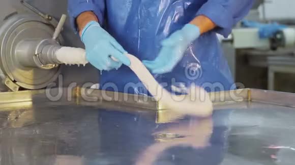 生产工人戴蓝色橡胶手套做香肠香肠的特写是由一个雇员创作的视频的预览图