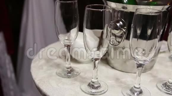 冰桶中的香槟瓶和六个玻璃杯视频的预览图