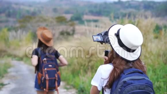 女制影师拿着装有无镜相机的万向节记录女性旅行视频的预览图