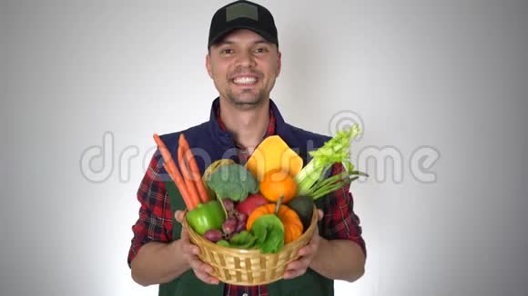 微笑的农夫手里拿着一篮子新鲜的有机水果和天然蔬菜视频的预览图