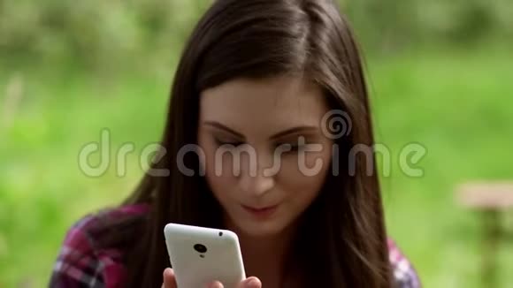 令人惊讶的年轻女孩看着她的手机外部视频的预览图