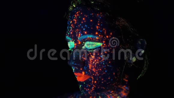 在黑暗的油漆中涂上了辉光在工作室摆着霓虹灯的时尚模特女士美丽的肖像视频的预览图