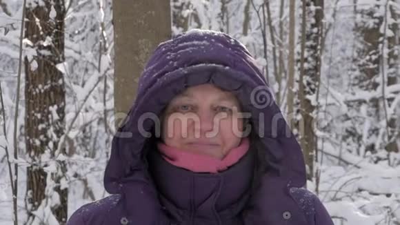 在冬季森林里接近迷人的高级妇女视频的预览图