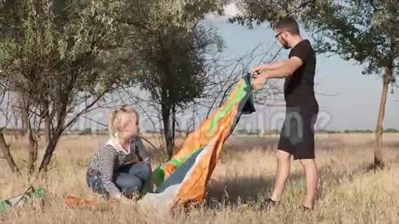 一对夫妇把帐篷搭在地上视频的预览图