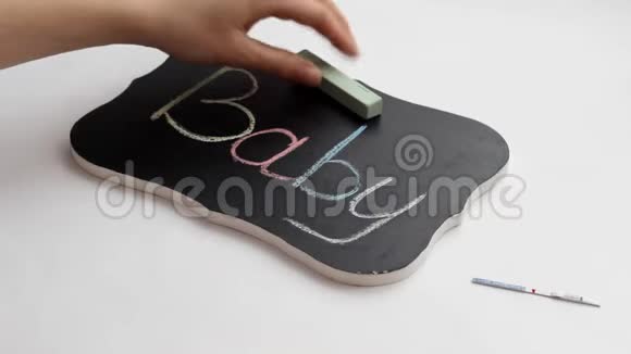 女孩用婴儿不育症妊娠试验手在盘子上划字视频的预览图