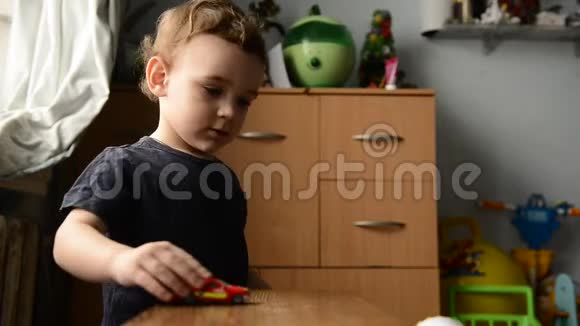 小男孩在孩子们房间里玩玩具车视频的预览图