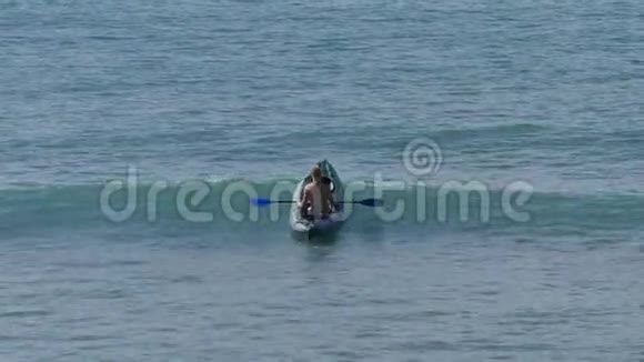 一个坐着皮艇的人冲着海浪视频的预览图
