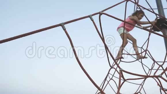 4女孩白天在沙滩上爬绳蜘蛛视频的预览图