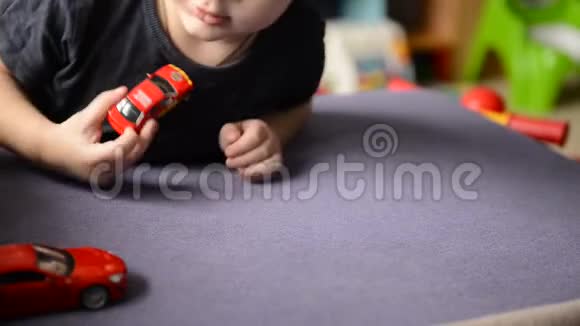 小男孩在孩子们房间里玩玩具车视频的预览图