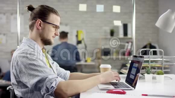 年轻人坐在办公桌前唱歌手提电脑周围都是各种各样的同事懒惰的工人浪费时间视频的预览图