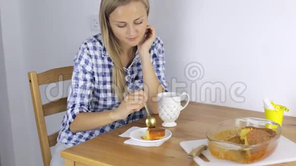 女人在家里的厨房里喝茶吃馅饼视频的预览图