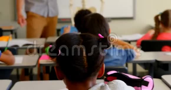 快乐的金发白种人女学生在4k教室的课桌上学习视频的预览图
