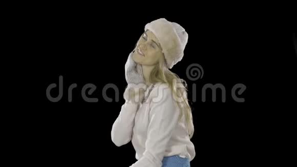 戴着帽子手套和脖子附近绣着石头的毛衣的优雅美丽的年轻女子展示了一些东西视频的预览图