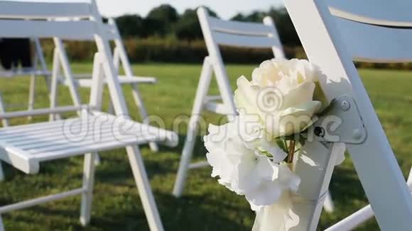 草地上装饰精美的白色藤椅视频的预览图