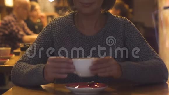 美丽的女性喝咖啡在咖啡馆享受热饮料的味道休息视频的预览图